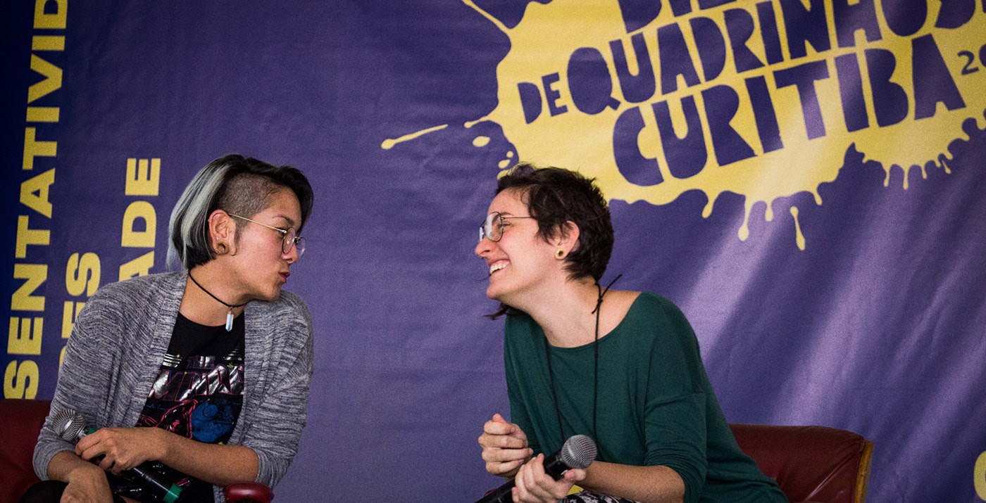 Mesa de debate com banner do evento